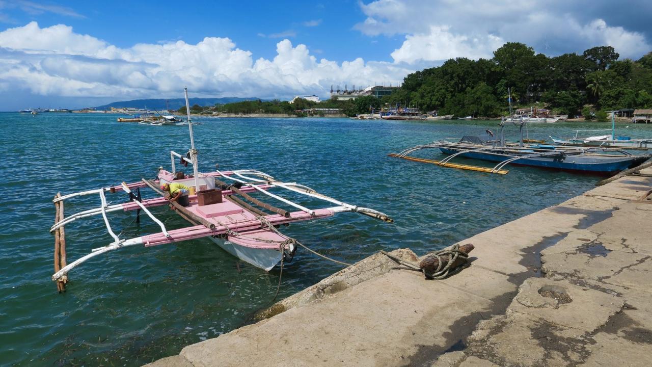 Pink Fishing Boat Docked in Local Village