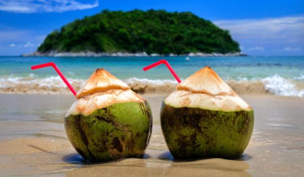 Coconut cocktail on the white Sands of the Paradise coast of Phuket island in Thailand.